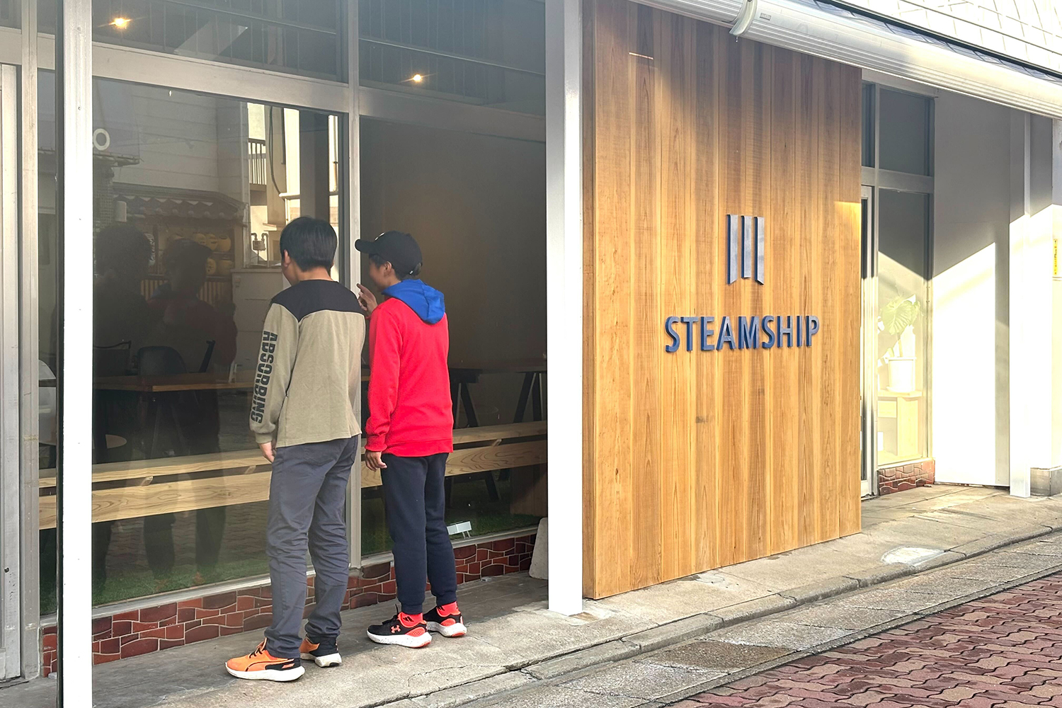 通りすがりに中をのぞく子どもたち。人々の目をひく外壁は糸島杉を使用